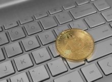 Монета биткоина на клавиатуре ноутбука