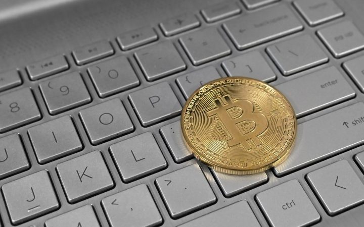 Монета биткоина на клавиатуре ноутбука