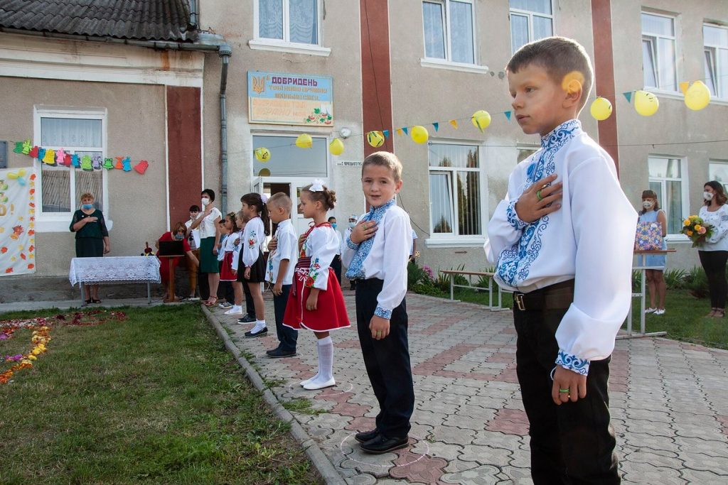 Школьники в вышиванках на линейке ко Дню знаний во дворе сельской школы