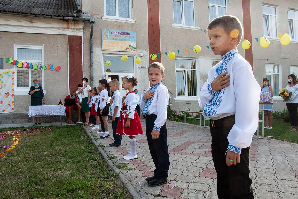 Школьники в вышиванках на линейке ко Дню знаний во дворе сельской школы